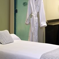 cropped photo of private spa room with white cotton robe