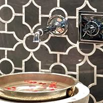 decorative basin with petals under ornate faucet with persian tile wall
