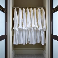 Spa closet with rack of white cotton robes for guests